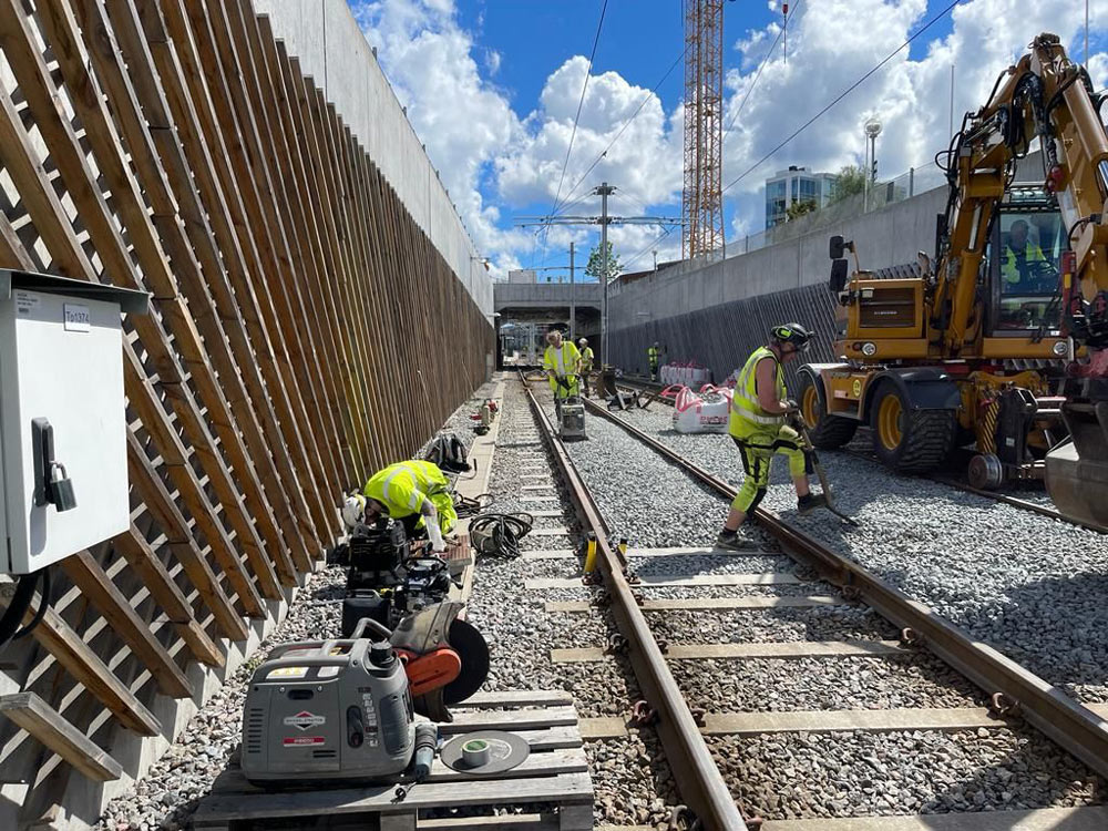 A man in an orange safety vest inspects the railway tracks