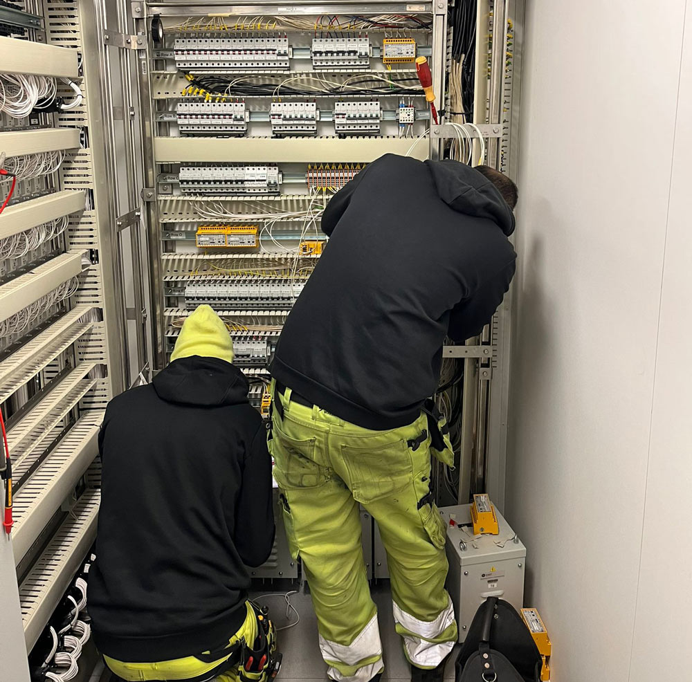 Man som arbetar vid ett elskåp