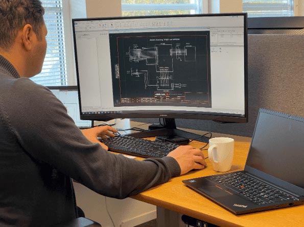 Man som sitter vid dator med ritningar