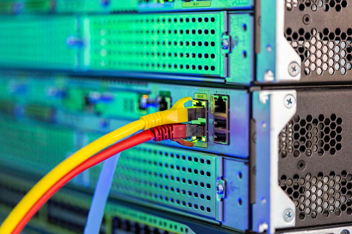 Gul och röd ethernetkabel som sitter i en dosa